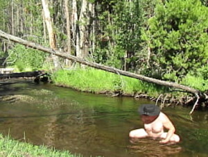 Bathing naked in the creek.